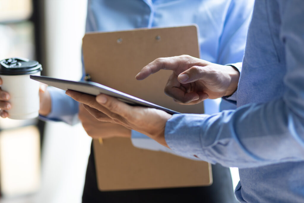 Two people reviewing a tablet during a discussion. Stock photography for illustrative context.