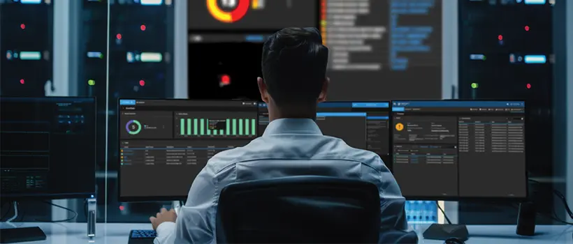Stock photo of a person reviewing dashboards. Decorative only; not Techloom staff or a customer environment.
